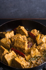 cooking jackfruit curry dish, tempering with oil and coconut milk, classic sri lankan vegetarian dish on a pan, closeup view - obrazy, fototapety, plakaty