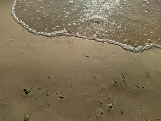 high tide on a sandy shore in the daytime top view.