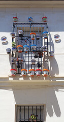 colorful pots with plants hanging from the window railings, Malaga, Spain