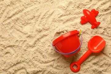 Fototapeta na wymiar Flat lay of beach toy kit on sand, space for text. Outdoor play