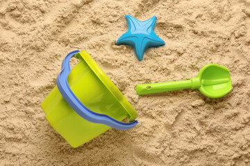Beach toy kit on sand, flat lay. Outdoor play