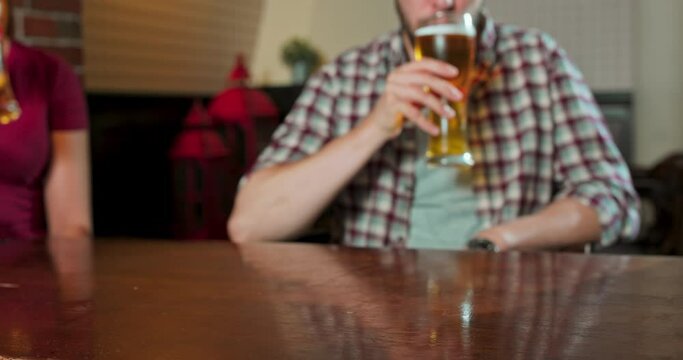 Group of friends enjoying a beer at pub in Poland. Close up and focus on glasses. Slow motion close up of clinking glasses in a pub. Concept of friendship, holidays, celebration.