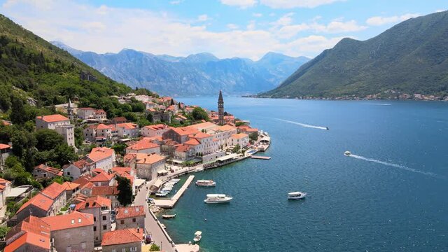 Perast travel destination in Montenegro. Sunny holiday touristic , old medieval town with red roofs by beautiful Kotor bay on the coast of Adriatic sea. Aerial view