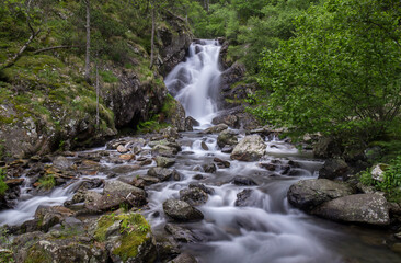 beautiful mountain waterfall with big stones and lots of water