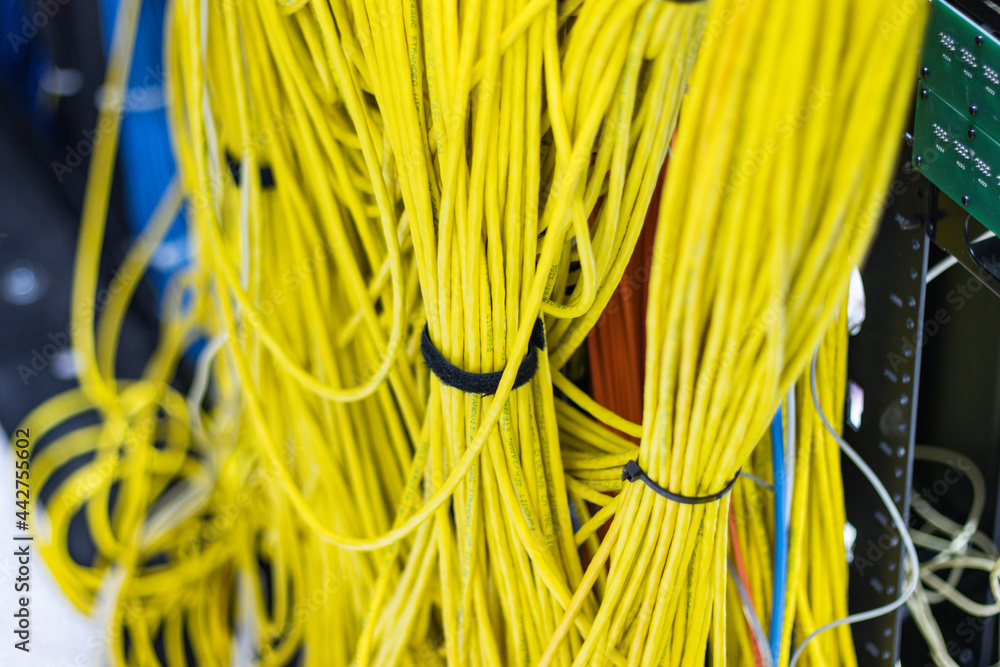 Poster the yellow network cables in the server room for connecting to a network internet