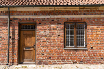 detail view of a wooden door and window in a red brick building