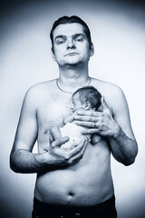 Father holding his newborn baby boy on his chest