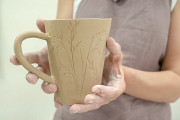 Woman hand potter holding finished clay product in pottery workshop studio. Handmade hobby art and handicraft concept