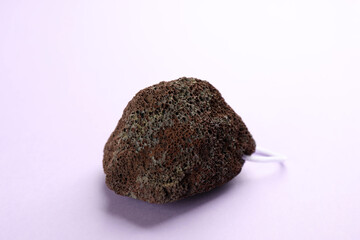 Pumice stone on violet background. Pedicure tool