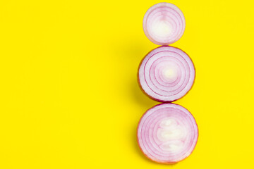 Sliced purple onion on yellow background