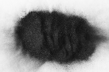 Fine black coal powder, small small granules on a white background. Close-up A pile