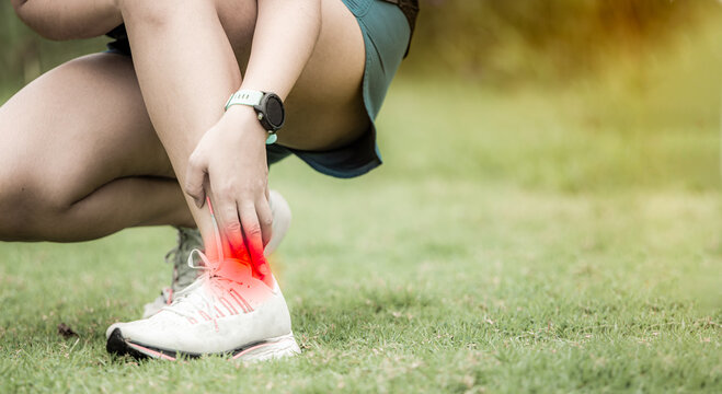 Sport woman has sore ankle from exercising training. It is a common injury for runner. Ankle pain, painful point. pressure point. achilles tendon painful.