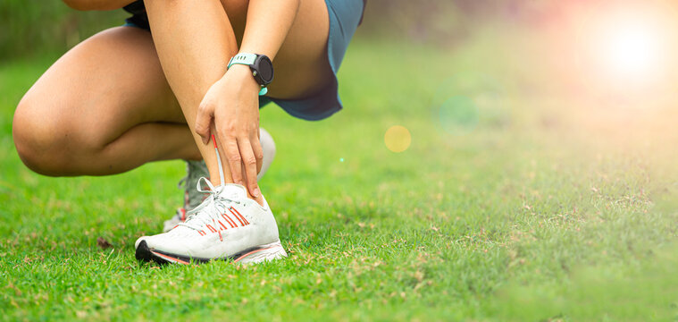 Sport woman has sore ankle from exercising training. It is a common injury for runners. Ankle pain, painful point.