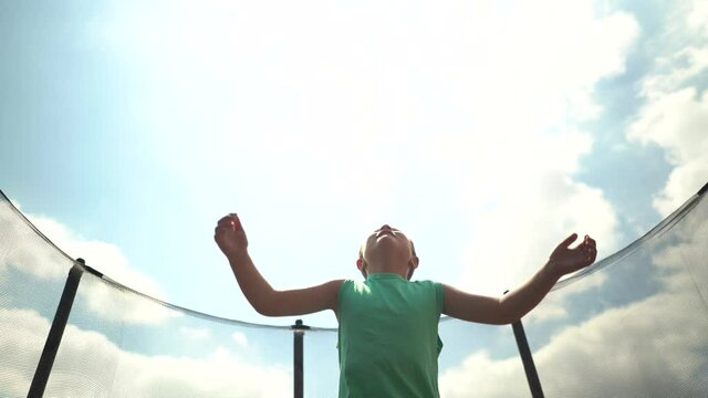 Ni&ntilde;o salta colchoneta elastica hasta el cielo