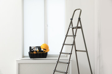 Window sill with tool box and ladder in room