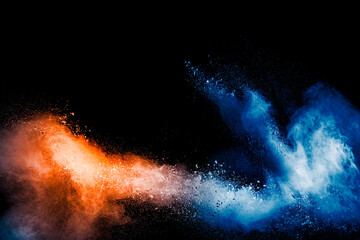 Orange blue color powder explosion on black background.