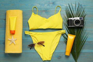 Different beach objects on light blue wooden background, flat lay