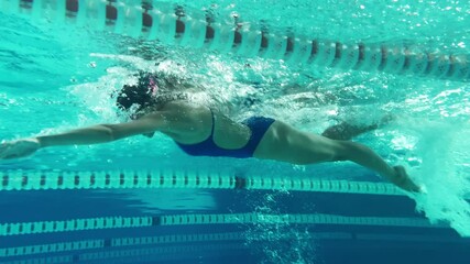 Underwater Shot: Fit Beautiful Swimmer doing Laps in Swimming Pool. Professional Female Athlete swims at Great Speed. Ready To Set World Championship Record. Colorful Artistic Stylish Tracking Shot