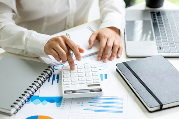 Financial Business women  use calculator analyze the graph of the company's performance to create...