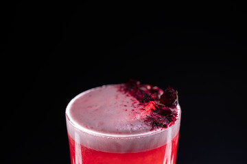 clover club cocktail drink with raspberry and rose petal on black background