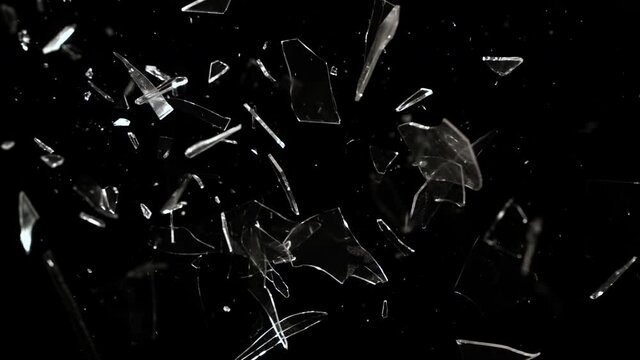 Super Slow Motion studio full-frame wide plate shot of window glass pane shattering and breaking on black background. Real smash explosion at high speed as action concept template and overlay element.