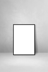 Black picture frame leaning on a light grey wall