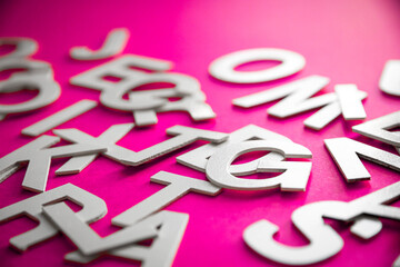Mixed letters pile close up view photo. Pink background