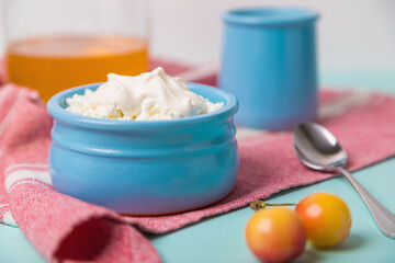 Cottage cheese in a blue bowl with sour cream and honey. Morning breakfast.