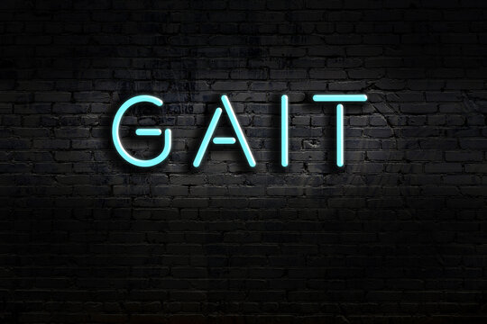Neon sign. Word gait against brick wall. Night view