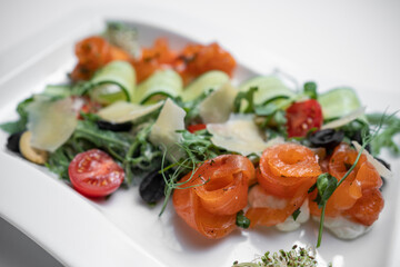 closeup of salad with lightly salted salmon and vegetables on white background