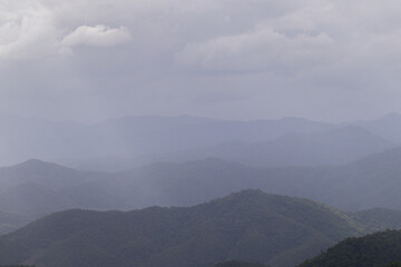 The beautiful scenery of the mountains in the rainy season after the rain has passed creates a beautiful and fresh air. Rainy season travel idea to see the beautiful scenery of the mountain forests.