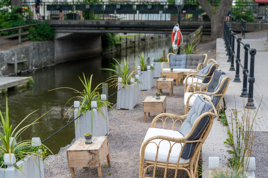 selective focus view of an idyllic waterfront patio of a restaurant with lounge chairs and small tables