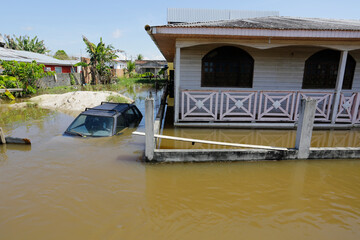 A car, left, is seen submerged near a house at a flooded street in Careiro da Varzea, near Manaus,...
