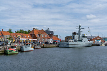 the harbor and port of Koge with colorful boats and a warship from the Danish navy