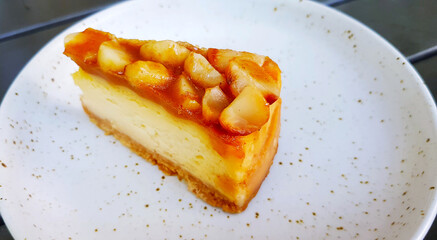 Macadamia cheesecake on white dish or plate with copy space on right. Sweet dessert and Homemade food at café shop.
