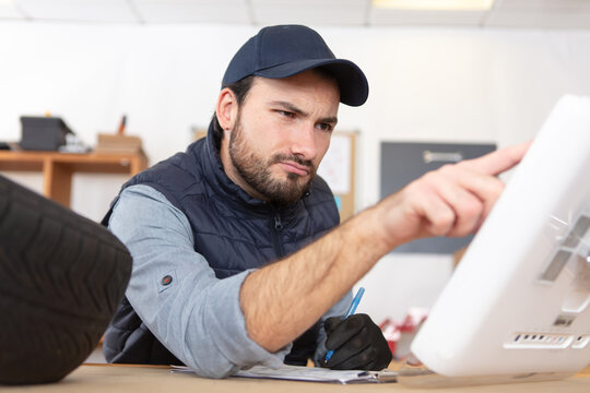 manual technician in workshop using a computer
