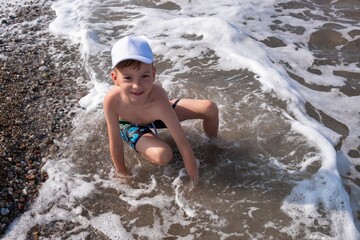 Happy child play in ocean or sea beach. nature playing