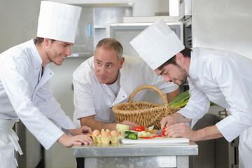 chefs preparing food in the kitchen of a restaurant