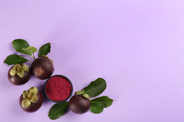 Mangosteen powder and fruits on violet background, flat lay. Space for text