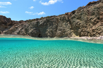 Underwater split photo of beautiful beach of Kalogria with emerald crystal clear sea, Milos island, Cyclades, Greece