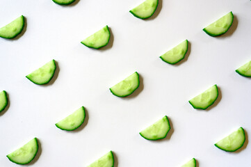 repeating pattern of sliced semicircles of fresh raw vegetable cucumbers for salad isolated on a...