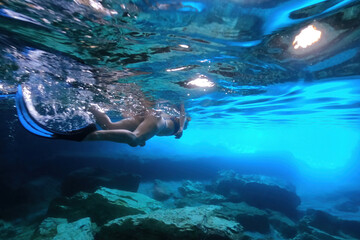Underwater photo of female diver in caves in Kleftiko, a beautiful scenic white volcanic rock...