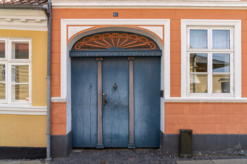 colorful blue wooden door and orange hosue front close up