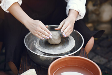 People making a vaze from a clay on a pottery's machine