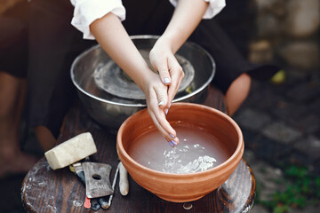 Obraz na płótnie Canvas People making a vaze from a clay on a pottery's machine
