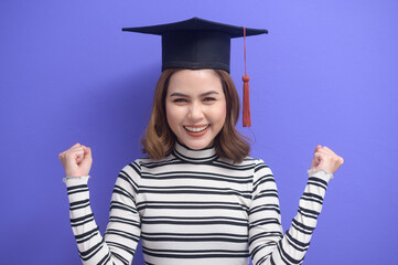 Portrait of young woman graduated over blue background