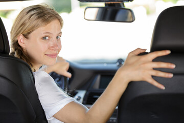 beautiful woman looking back while driving car