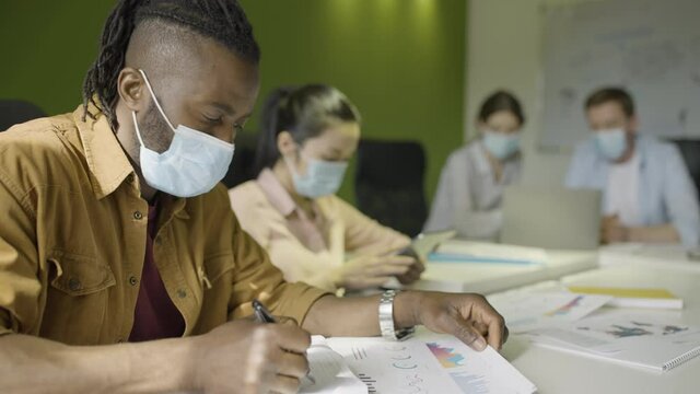 Business office employees working in protective masks during covid-19 pandemic