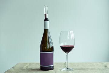 A bottle and glass of red wine on white background