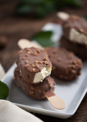 Chocolate ice lolly with almonds on the wooden vintage table